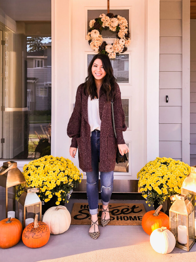 Fall front porch with fall wreath, fall mums, pumpkins, Home Sweet Home doormat from Target, Just A Tina Bit Seattle fashion blogger is wearing a cozy cardigan, leopard flats