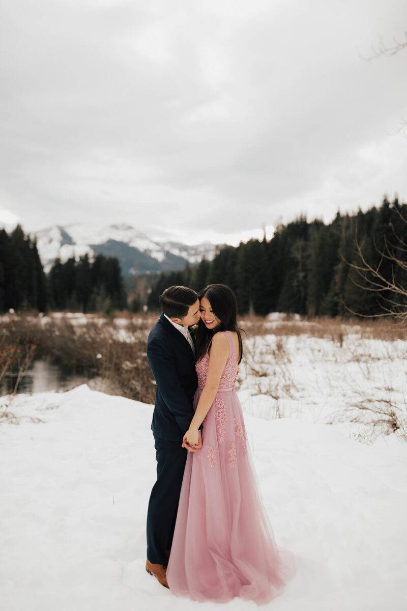 Winter formal engagement photos at Gold Creek Pond in Snoqualmie, Washington, snow photo shoot session, pink blush gown, affordable engagement gown from Amazon, engagement bouquet, engagement shoot outfits