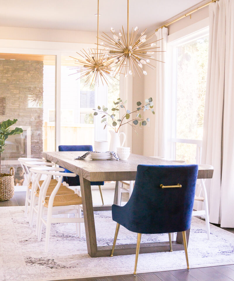Dining room design, sputnick lights, starburst pendant lights, brass accents, wishbone chair, blue velvet with handle dining chair