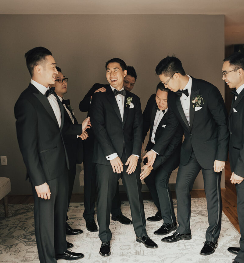 Seattle wedding, groom getting ready photos, wedding outfit for groom, groom wearing polka dot bow tie, The Black Tux peak lapel tuxedo, groom and groomsmen photos getting ready