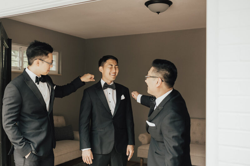 Seattle wedding, groom getting ready photos, wedding outfit for groom, groom wearing polka dot bow tie, The Black Tux peak lapel tuxedo