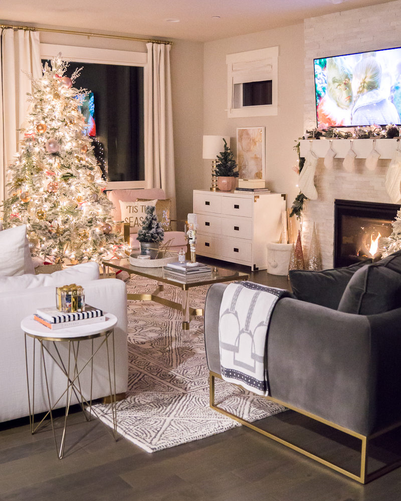 Pink and gold Christmas decorations 2019, blush chairs, living room interior design, flocked Christmas tree, fireplace garland with pink flowers, cozy stone fireplace, Target marble side table