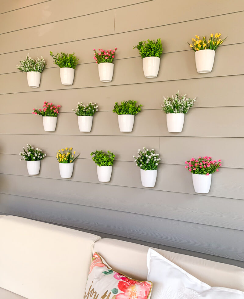 DIY plant wall decor for patio, outdoor design, faux flowers in hanging white pots, easy project for outdoor design