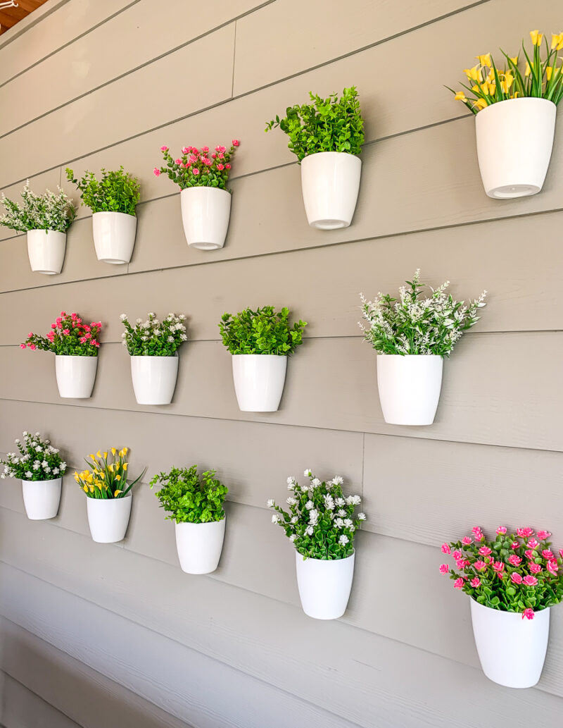 DIY plant wall decor for patio, outdoor design, faux flowers in hanging white pots, easy project for outdoor design