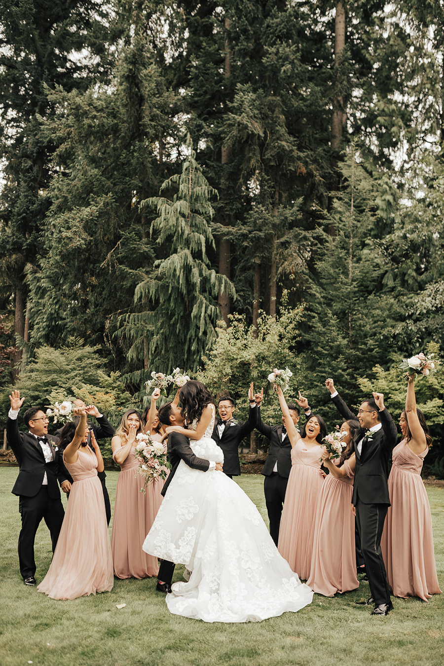8 poses to take with your wedding party - wedding party cheers while bride and groom kiss