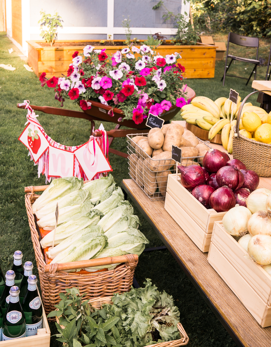 One year old birthday party, farmer's market birthday party idea, farmers market display, wheelbarrow with flowers, baskets with fruits and veggies