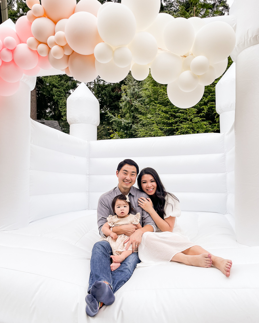 white bounce house in Seattle WA, white bounce house with balloon garland for one year birthday party, Instagrammable white bounce house for parties in Seattle, first birthday party white bounce house, family photo first birthday