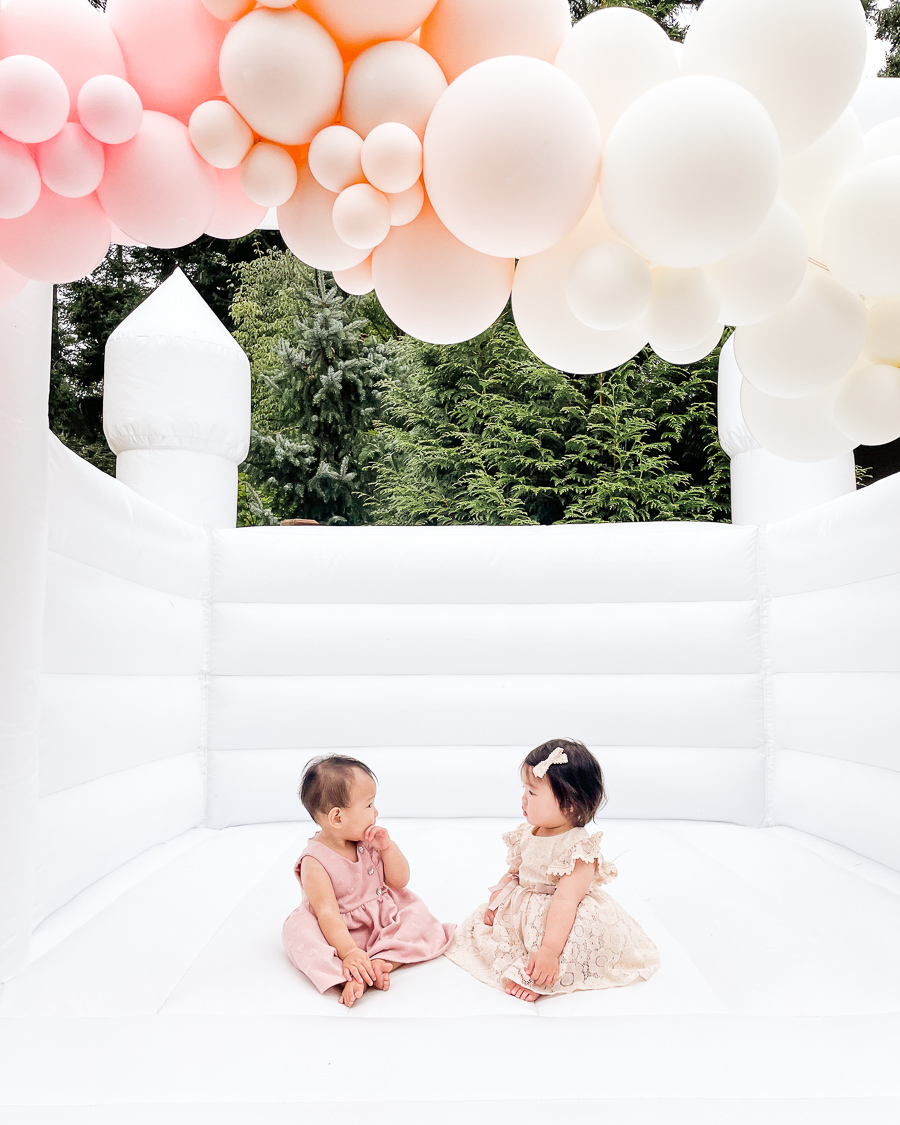 white bounce house in Seattle WA, white bounce house with balloon garland for one year birthday party, Instagrammable white bounce house for parties in Seattle, one year old birthday party ideas