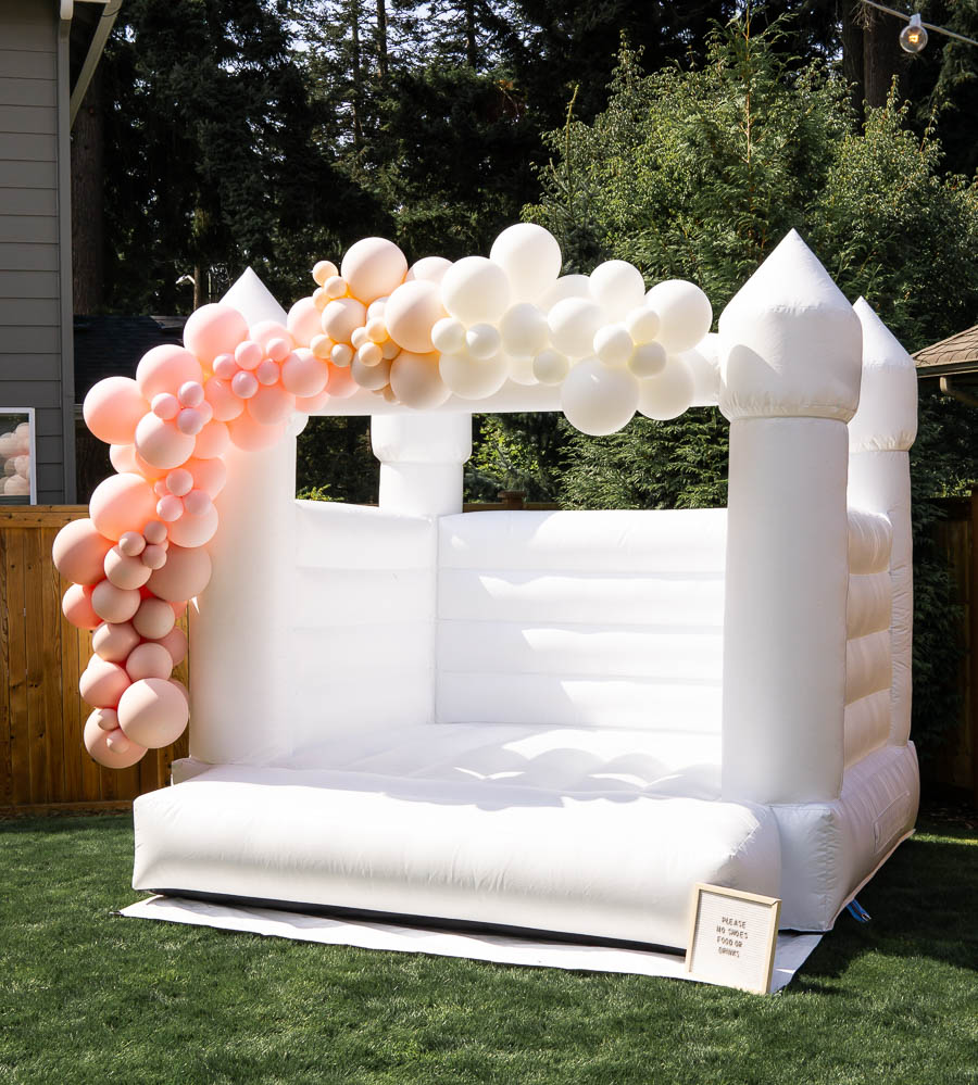 white bounce house in Seattle WA, white bounce house with balloon garland for one year birthday party, Instagrammable white bounce house for parties in Seattle