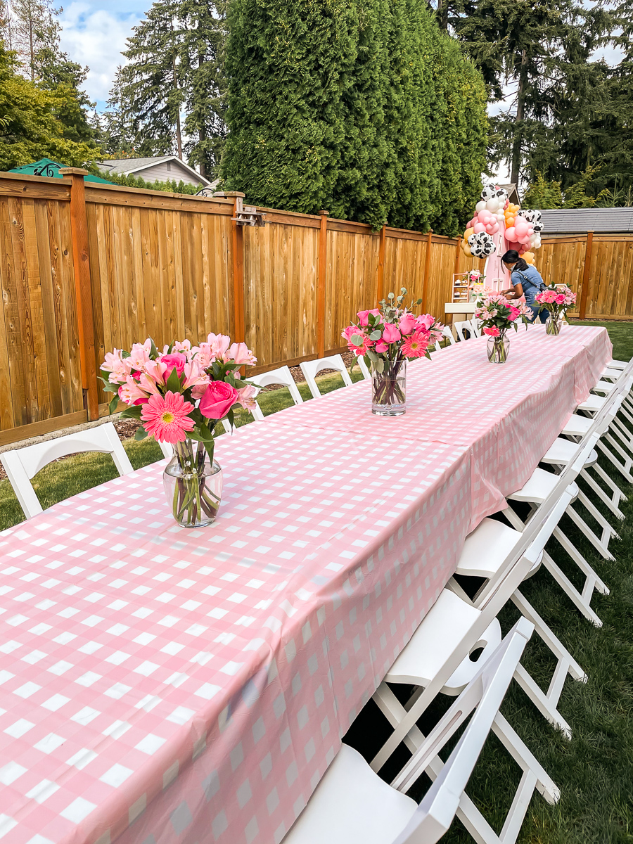 Pink gingham tablecloths, pink birthday set up, Costco bulk flowers