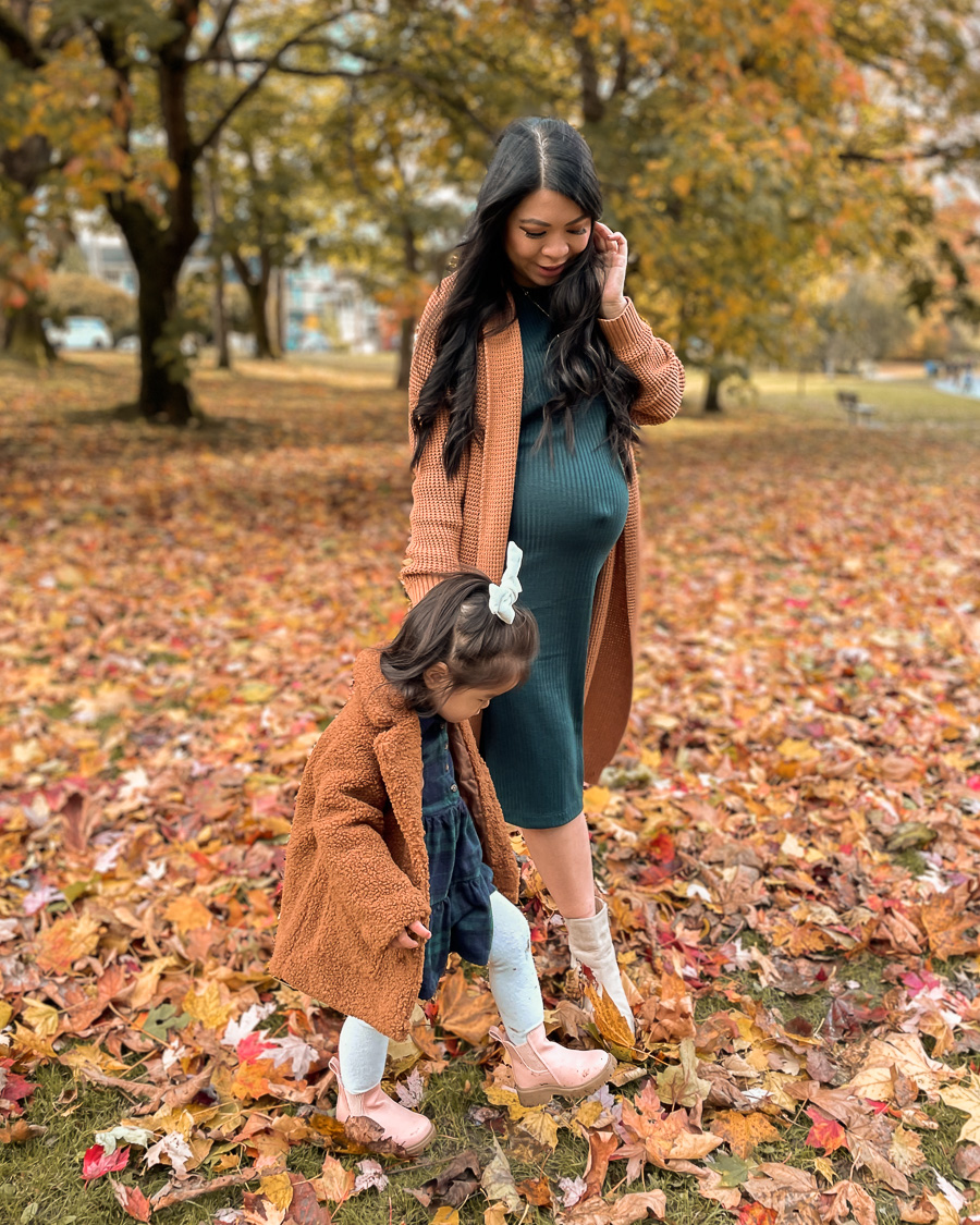 mommy and me thanksgiving outfit, dark green maternity and nursing dress with cardigan, toddler teddy coat with plaid dress and chelsea boots, fall family photos