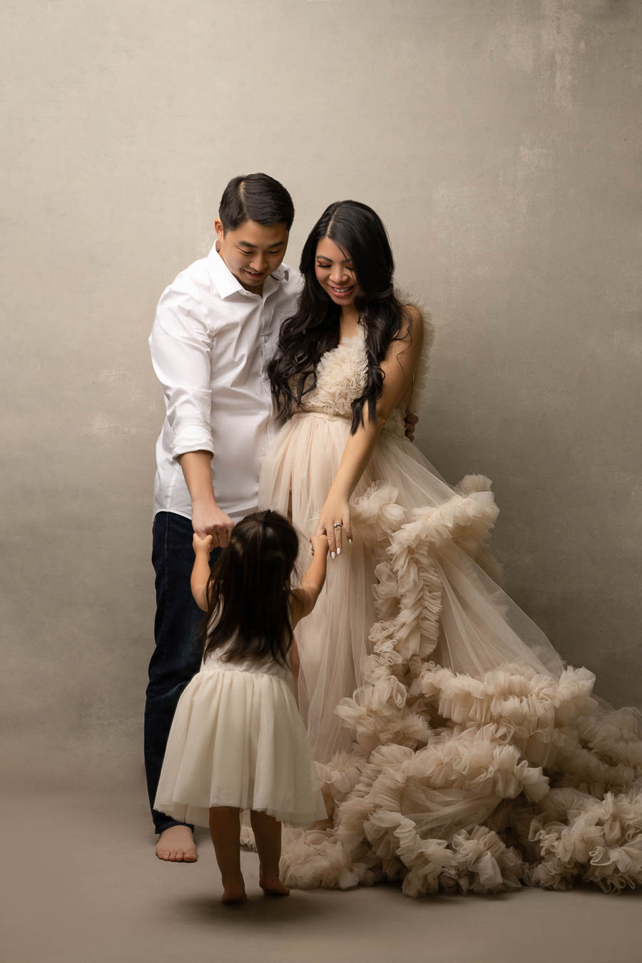 studio mommy and me maternity photo shoot, family maternity photo with ruffle tulle dress, mom, dad, and toddler girl