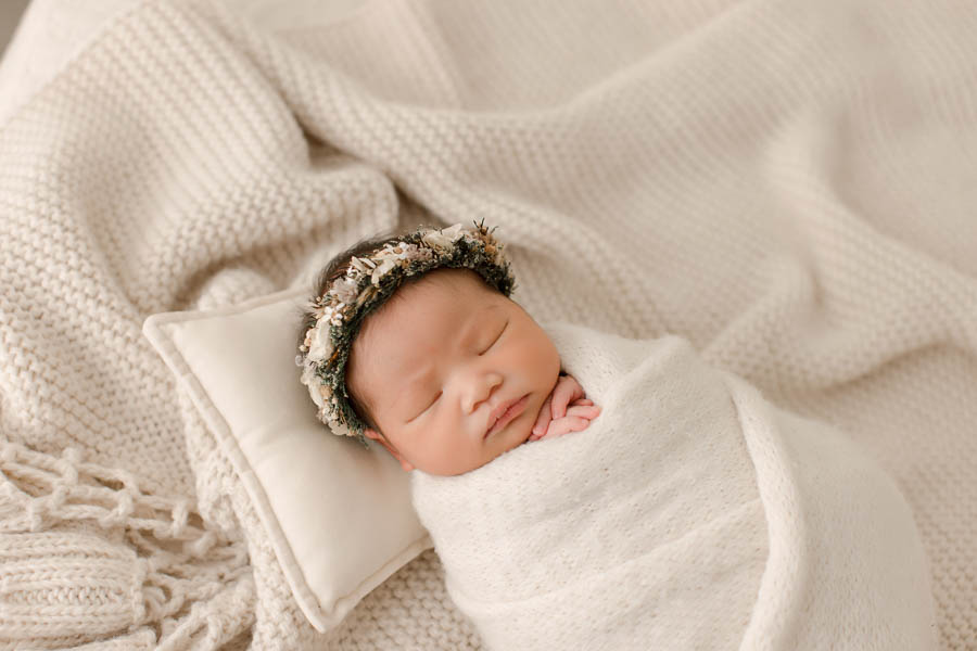 newborn with flower crown wrapped