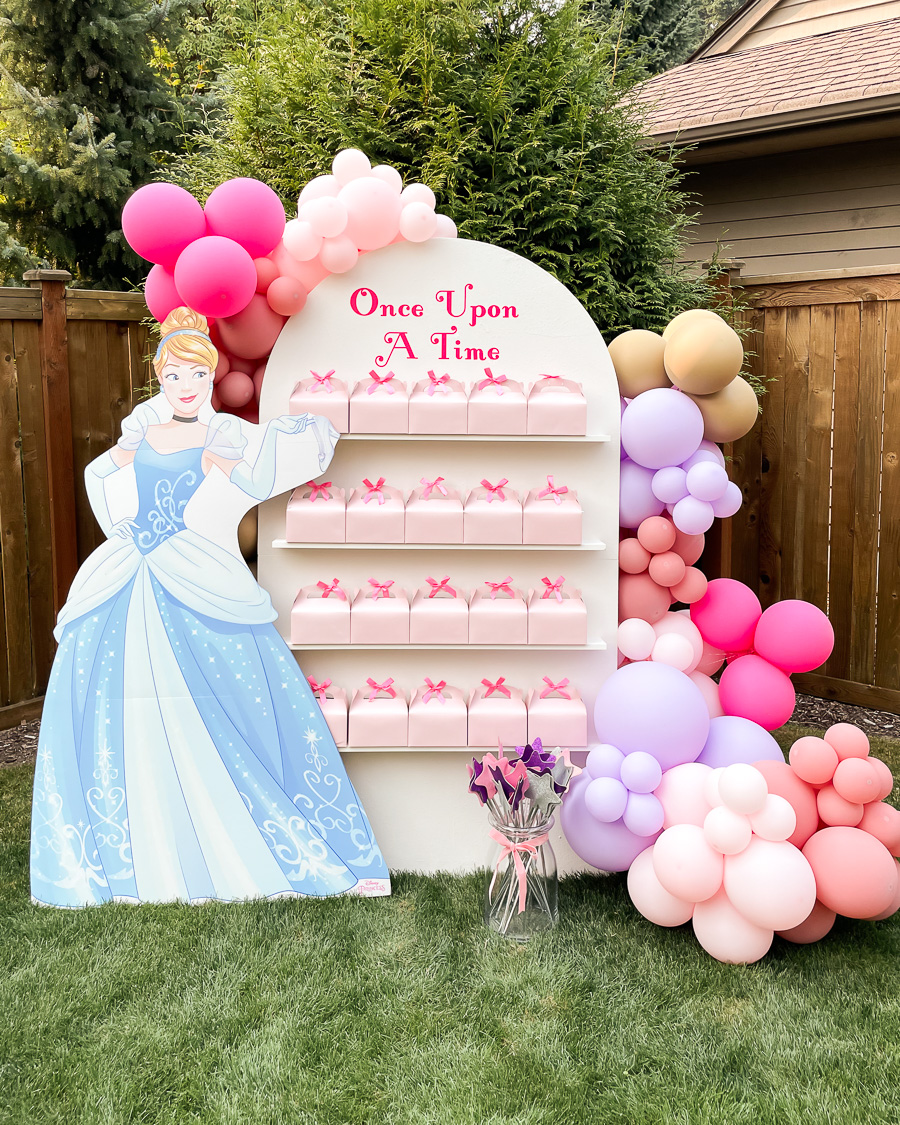 princess party, arch party favor wall with Cinderella cutout, pink party favor boxes, glittery wands, and pastel balloon garland, once upon a time vinyl decal