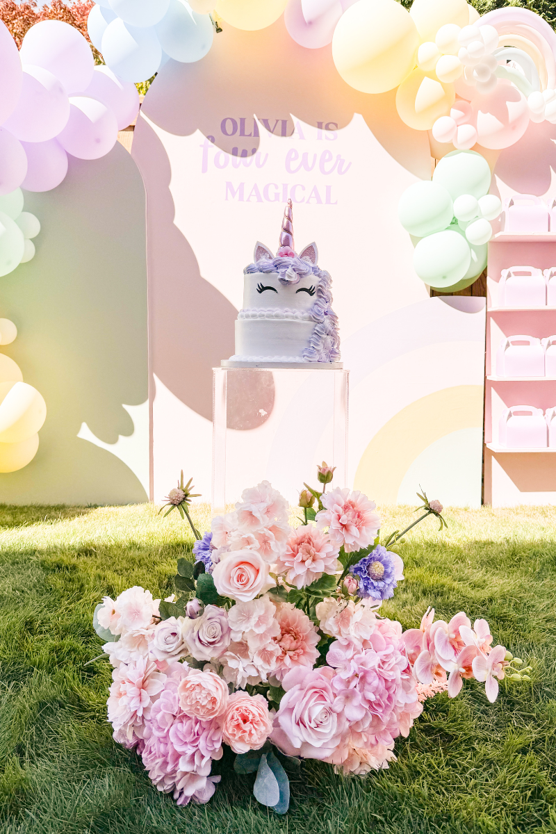 Two-Tiered Unicorn Cake with unicorn horn topper and pastel piped rosettes