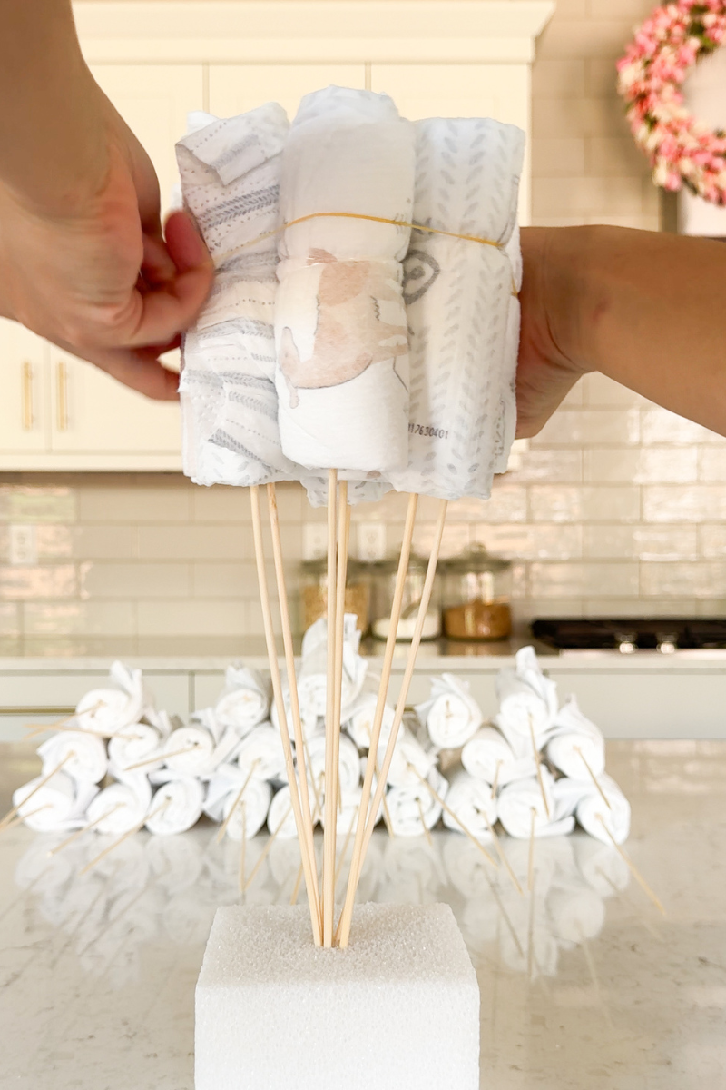 diaper bouquet tutorial - securing the first layer with large rubber band